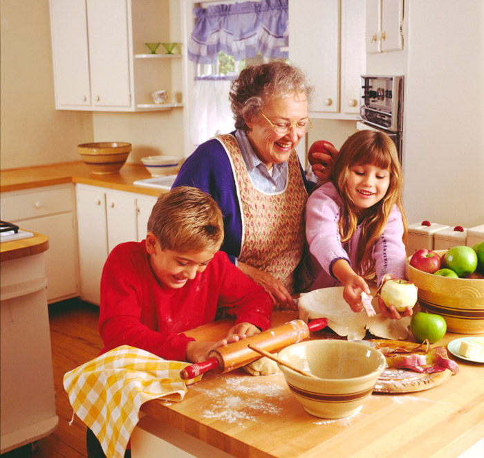 young boy and girl baking a pie with grandma